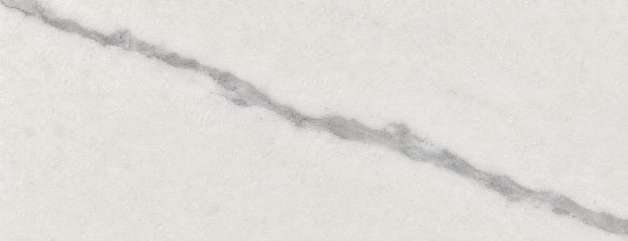 Marbre blanc poli mat de type Carrare, une seule veine grise traversant la surface en diagonale sous une lumière diffuse.