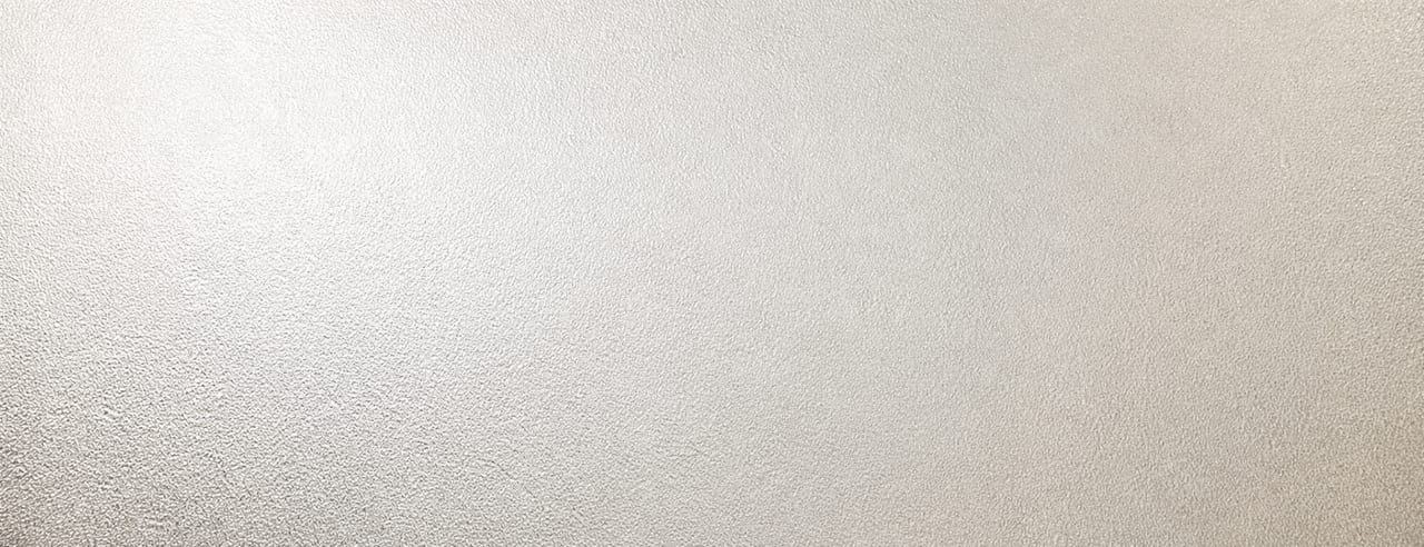 Verre dépoli d'une fenêtre d'atelier voilé d'une condensation fine et uniforme, traversé par la lumière du jour.