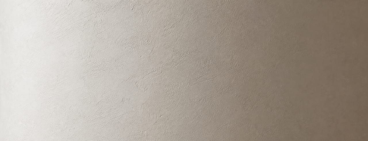 Mur incurvé en plâtre blanc haussmannien, dégradé continu du clair vers l'ombre douce, micro-texture du plâtre lisible.